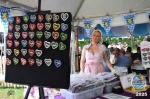 Woman selling heart-shaped gingerbread at Oktoberfest Miami 2025.