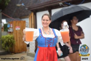 Smiling woman holding beer at Oktoberfest Miami 2025.