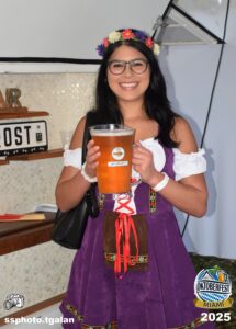 Woman in costume holding Oktoberfest beer pitcher.