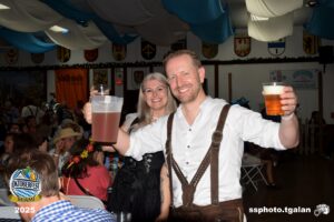 People celebrating Oktoberfest Miami, holding beer.