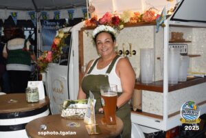 Woman serving beer at Oktoberfest Miami 2025 event.
