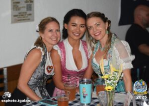 Three women in traditional attire at Oktoberfest Miami 2025