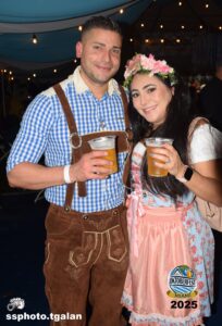 Couple enjoying drinks at Oktoberfest Miami event.