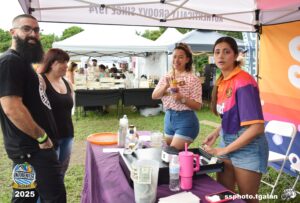 People at Oktoberfest Miami 2025 event booth.