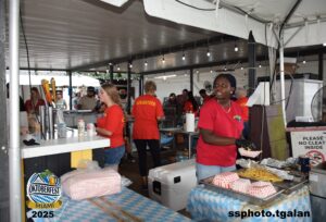 Volunteers serving food at Oktoberfest Miami 2025 event.