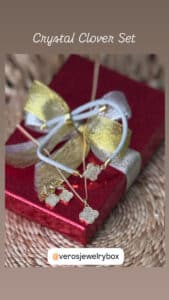 Gold clover jewelry set on red gift box.