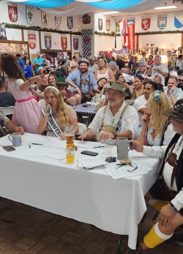 Crowded Oktoberfest celebration with people in traditional outfits.