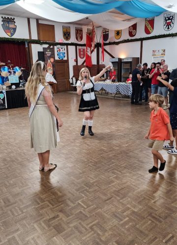 Woman singing in traditional German attire at event.
