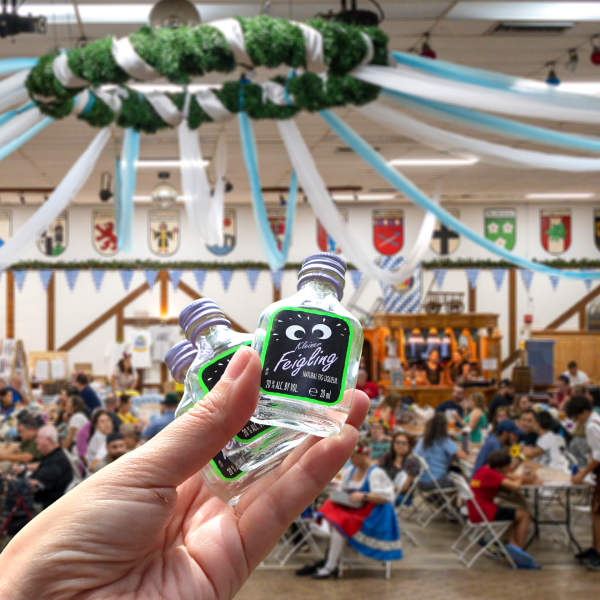 Hand holding bottles at festive event hall.